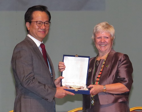 Host Organising Committee chair, Young Sik Kim receives presentation from Amanda Howe